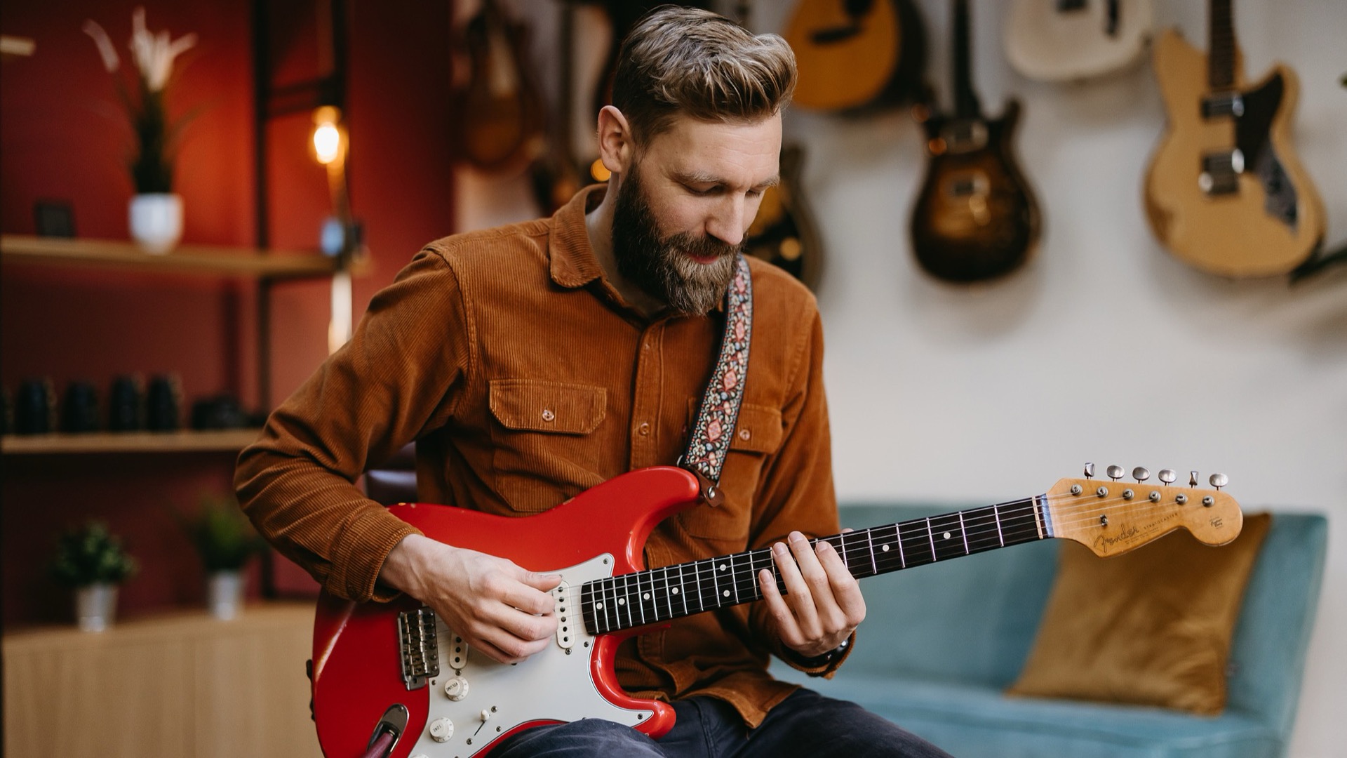 Paul Davids playing guitar in his studio.